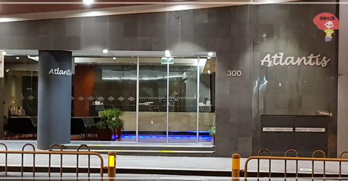 멜버른-아틀란티스-호텔-입구-야경-유리문-파란-조명