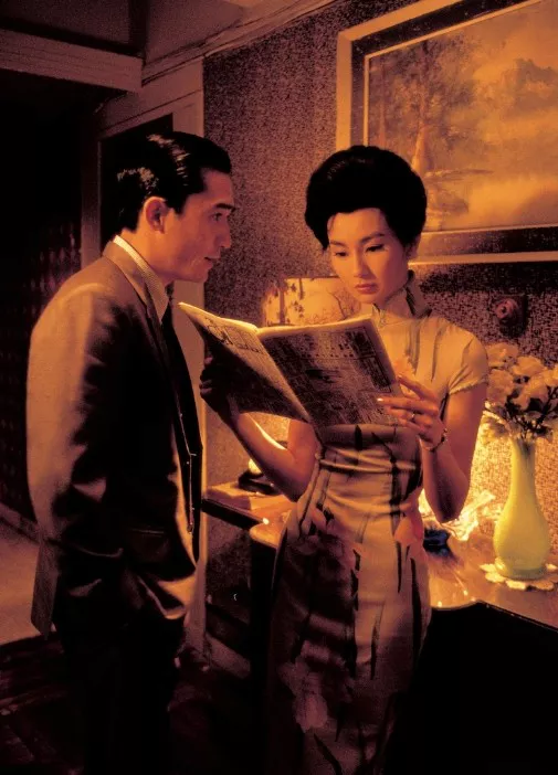 차파오를 입고 신문을 읽는 여자와 그녀를 바라보는 남자