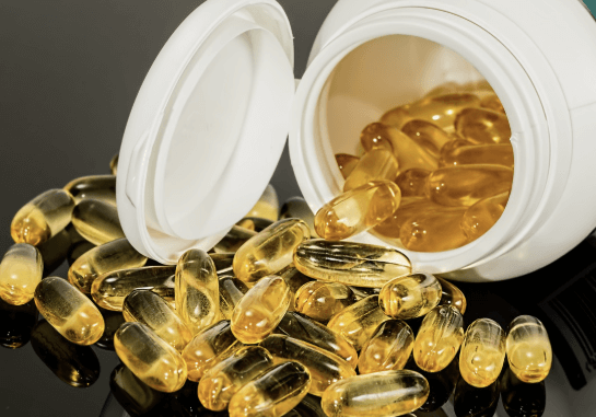 접시에 놓인 다양한 알약과 캡슐. 알부민 포함 단백질 보충제