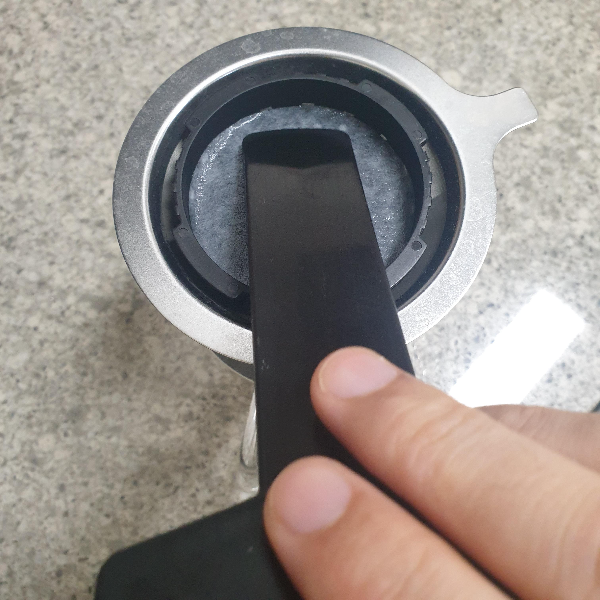 막대를 이용해 필터를 캡에 밀착시키고 있다.