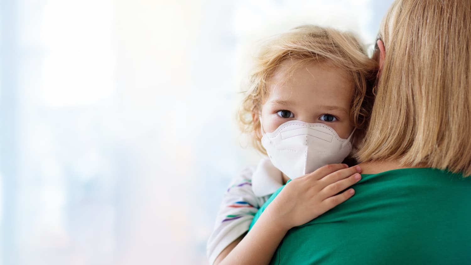 엄마에게 안긴 마스크 쓴 아이