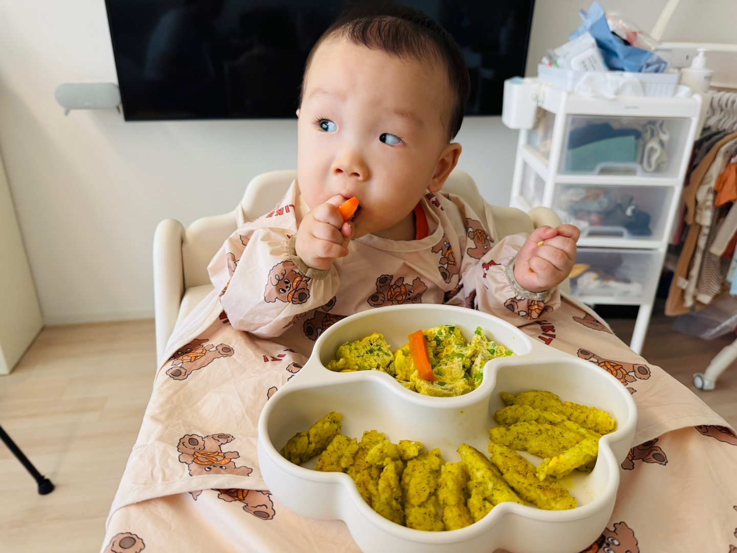 애호박달걀찜과 밥스틱이 담긴 식판 앞에서 당근스틱을 먼저 집어먹는 찬솔이