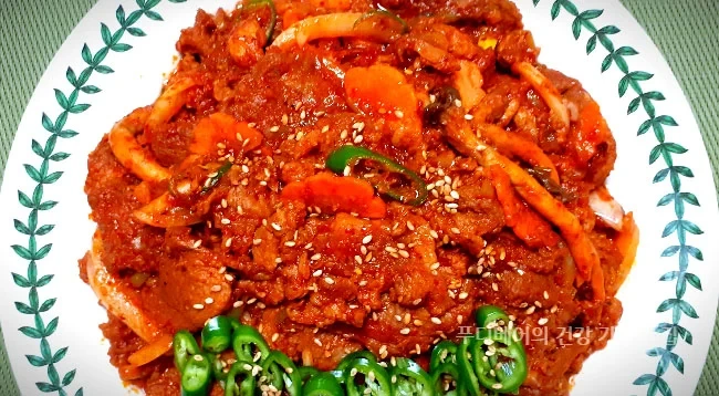 완성된-고소하고-쫄깃한-매콤달콤-돼지주물럭-제육볶음이-넓은-접시에-담겨져-있음-채썬-파란-청양고추가-올려져-있음