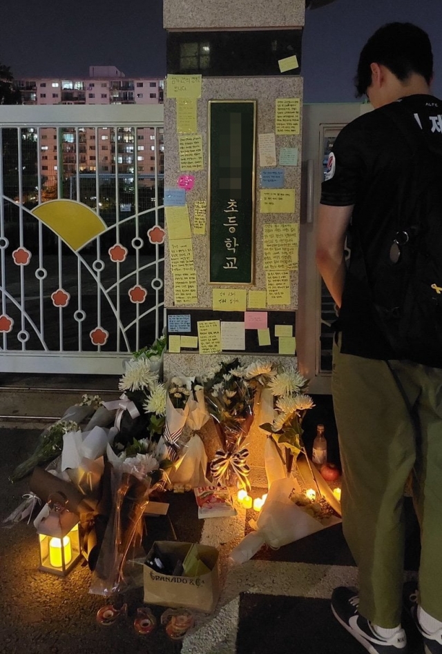 서울의 한 초등학교 교사가 극단적 선택을 한 사실이 알려지면서 이 학교 정문에는 동료 교사들의 추모 발길이 이어지고 있다