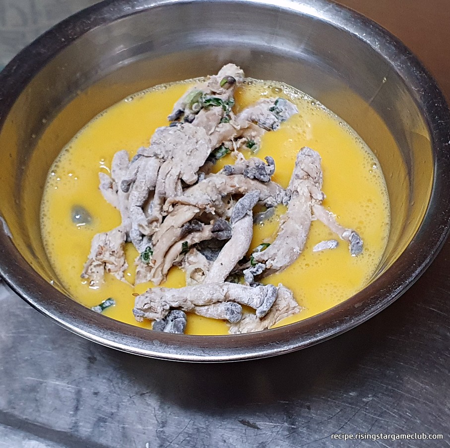 밀가루 옷을 입힌 느타리버섯에 계란옷을 입히는 사진