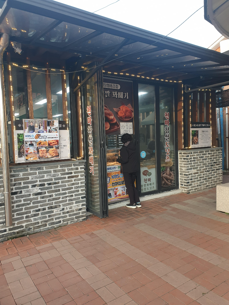 꽈배기집 앞에 손님 한명이 기다리고 있다. 창문에는 TV 출연 장면이 붙어있다.