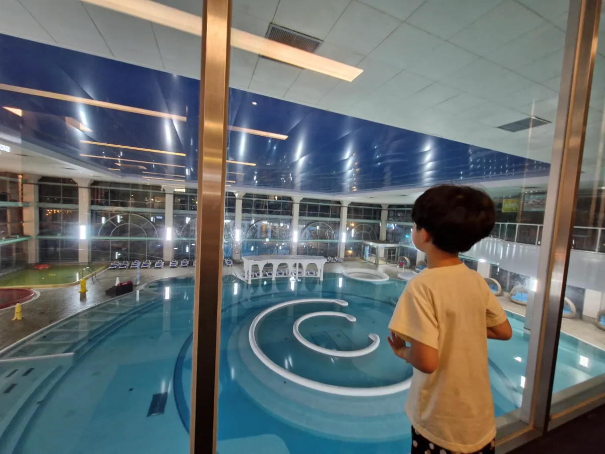 남자아이가-수영장을-위에서-아래로-내려다보고-있다