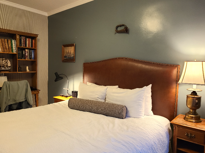 침대의 모습. 하얀색의 이불과 베개.