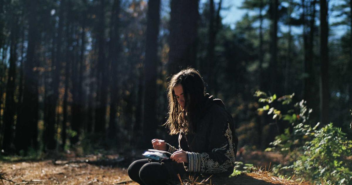 Young person happily managing their budget on a laptop with multiple colorful savings jars