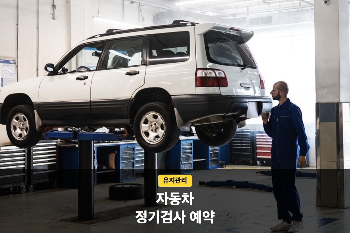 자동차 정기검사 예약 전 정비소 리프트에 올린 흰색 SUV를 정비사가 살펴보는 모습