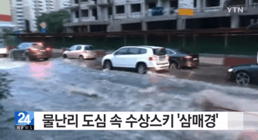 물난리난 침수도로에서 수상스키 타는 사람