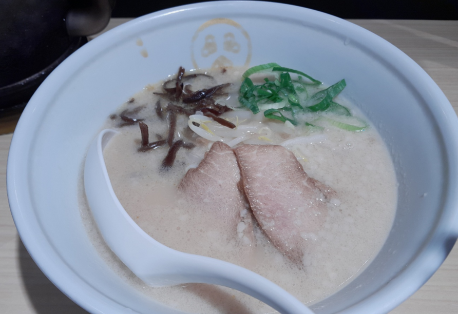 흰색 그릇안에 하얀 국물의 라멘이 들어가 있다. 국물 위로는 일본식 수육인 차유와 파 그리고 콩나물이 조금 보인다.