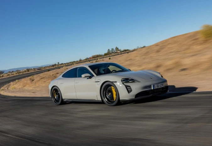 2024-포르쉐-타이칸-GTS가-도로에서-코너링하고-있으며-뒤의-배경을-통해-속도감이-느껴진다.