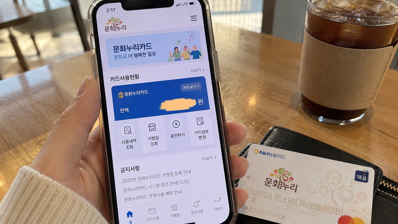스마트폰에 문화누리카드 모바일 화면을 띄우고 카드 잔액과 사용내역 조회 메뉴를 확인하는 모습