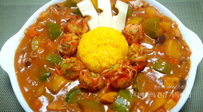 고기없이-진한-채소-카레에-강황밥과-슬라이스한-에멘탈치즈를-올려-접시에-플레이팅-해놓은-모습
