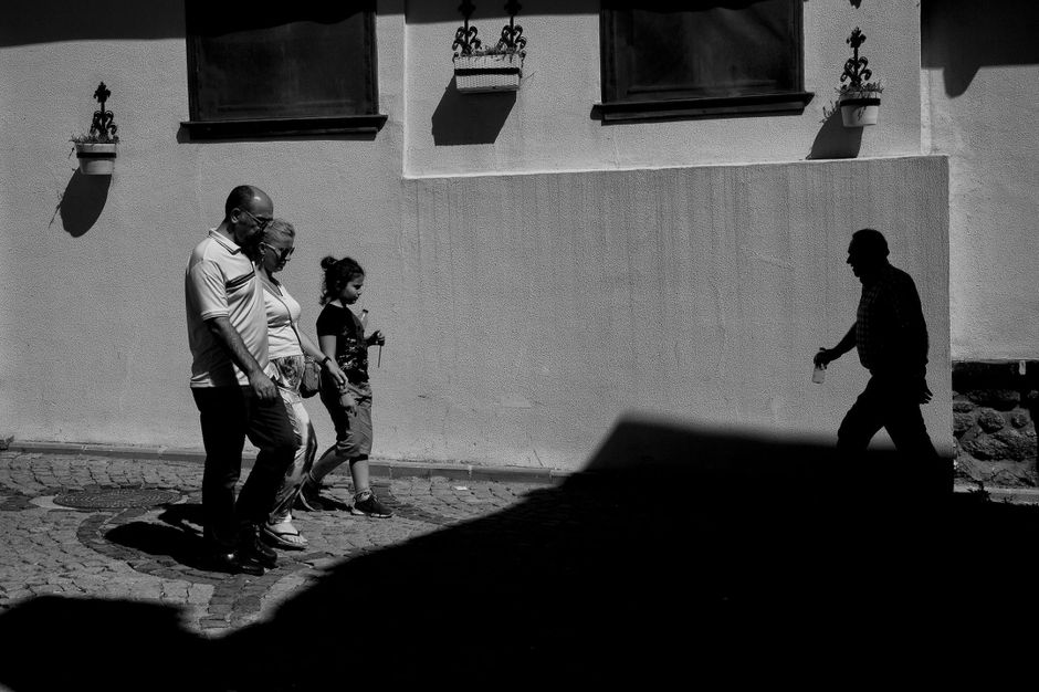 Captivating street scene in monochrome featuring people and deep shadows.