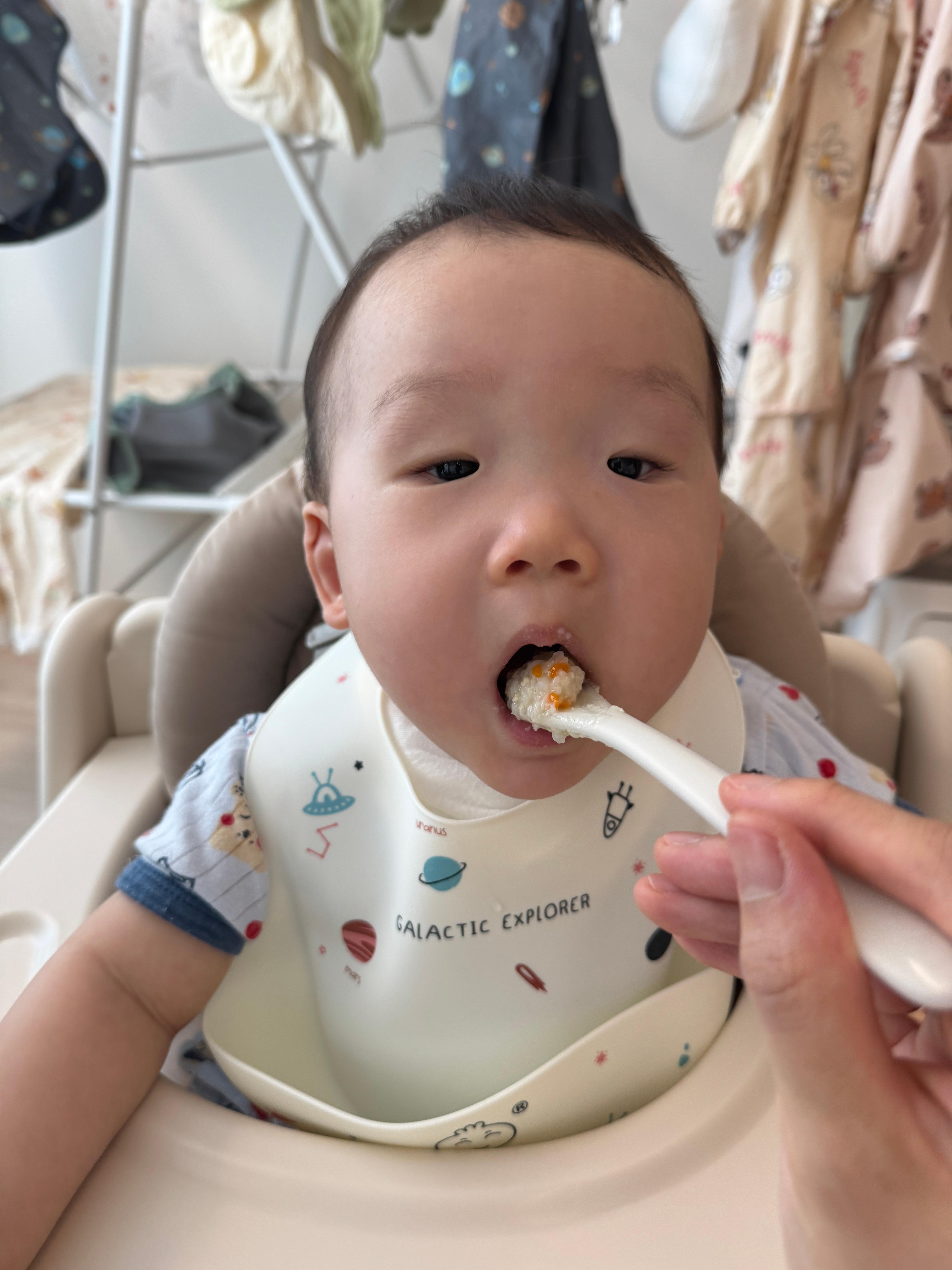 닭고기당근브로콜리 죽을 먹으려고 입을 크게 벌리고 있는 아기 모습