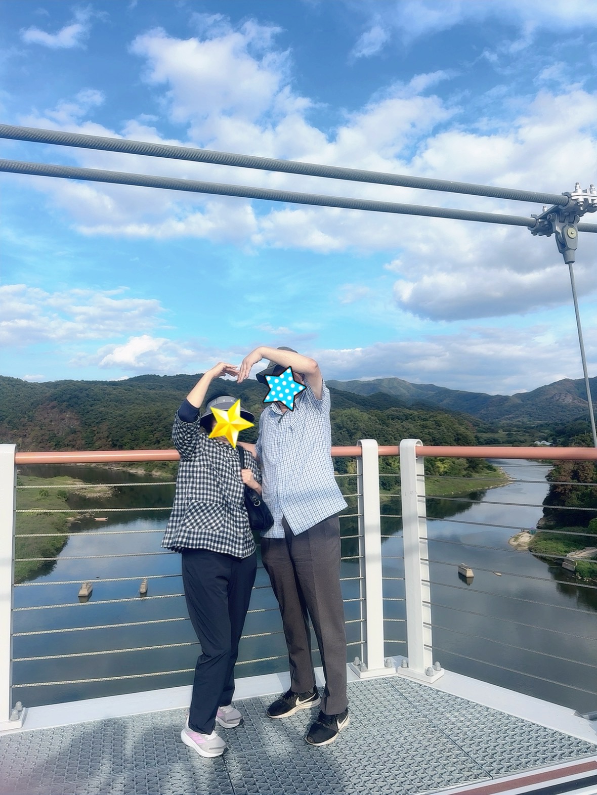 연천 베개용암 출렁다리 위에서 한탄강과 초록 산을 배경으로 기념사진을 찍는 가족
