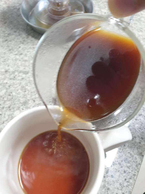 추출된 커피를 컵에 따르는 모습. 서버 내 커피에 오일 성분이 보인다.