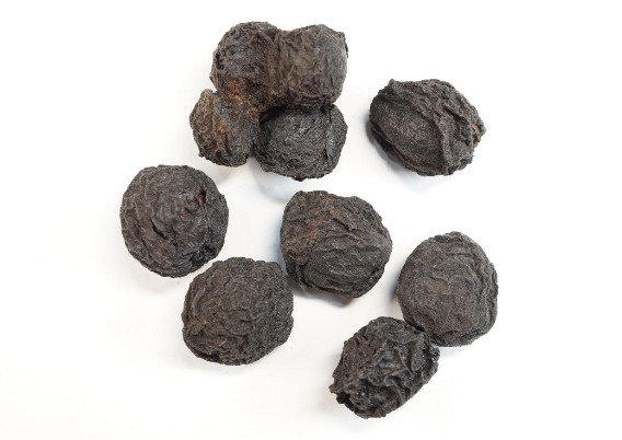 덜 익은 푸른 매실을 짚불 연기에 그을리고 말려서 만든 린 '오매'를 바닥에 놓아둔 사진