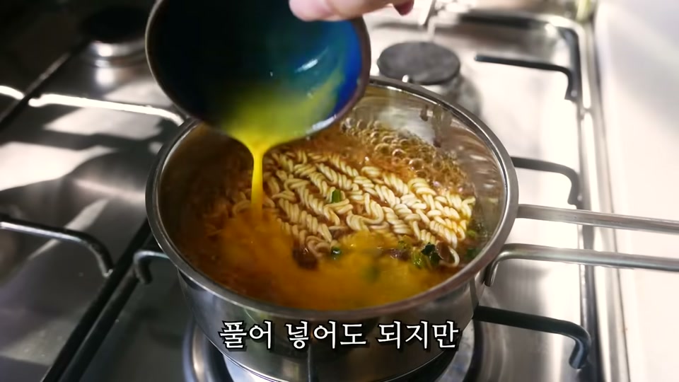 풀어 둔 계란물을 냄비에 붓는 장면