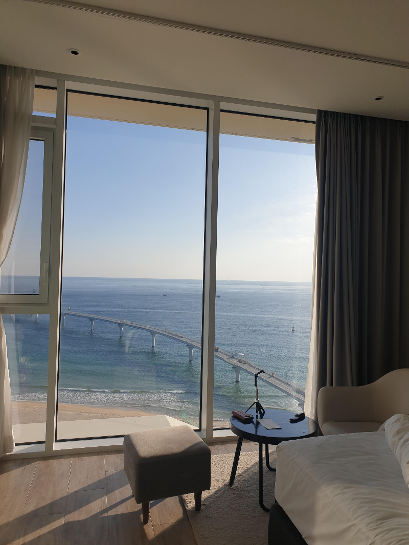 바다가 보이는 큰 창이 침대 아래쪽에 있다.