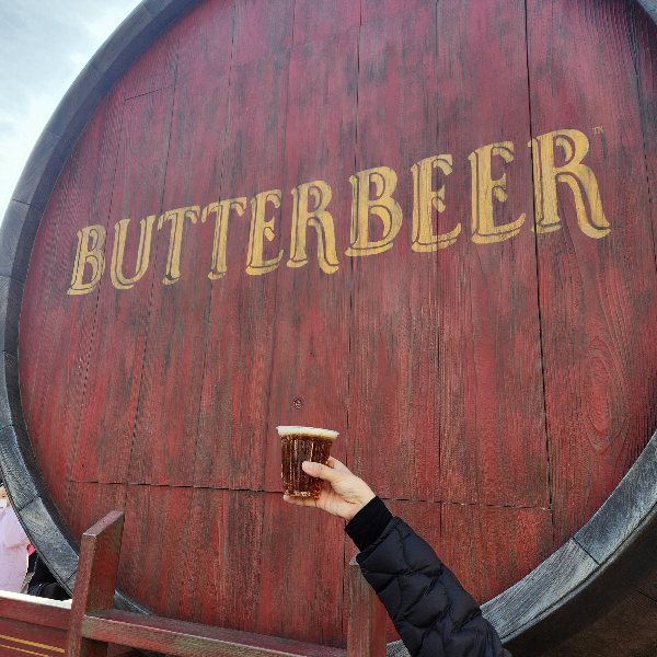 버터맥주 오크통 모형 앞에 버터 맥주를 들고 한 컷