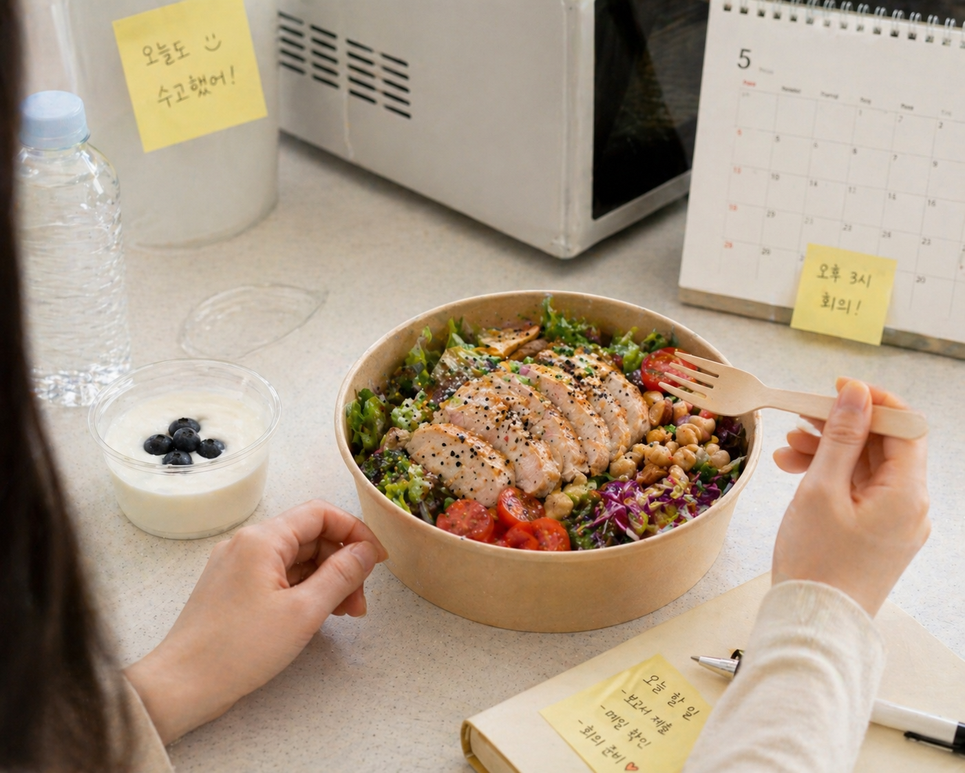 사무실 탕비실에서 직장인 여성이 닭가슴살 샐러드볼로 점심 식사를 하는 장면