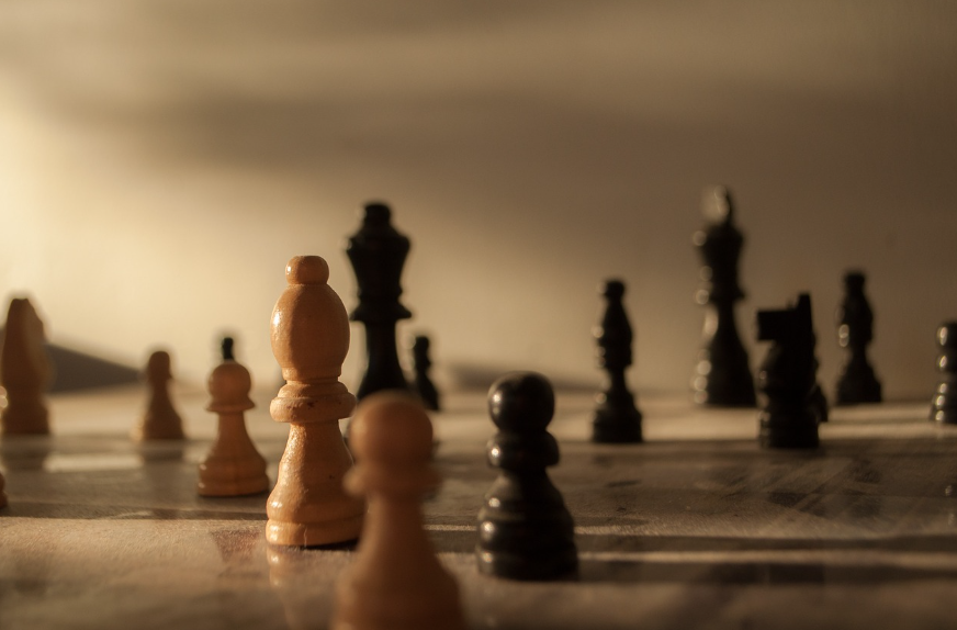 빛을 받은 흰색 체스 말이 어두운 체스판 위에서 다시 일어서는 모습을 상징적으로 표현한 이미지 - 실패 후 루틴을 다시 시작하는 심리적 회복력과 재도전의 의미