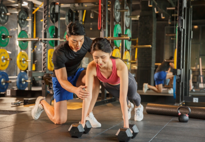 헬스 피팅받고 있는 여자와 교육하고 있는 헬스트레이너