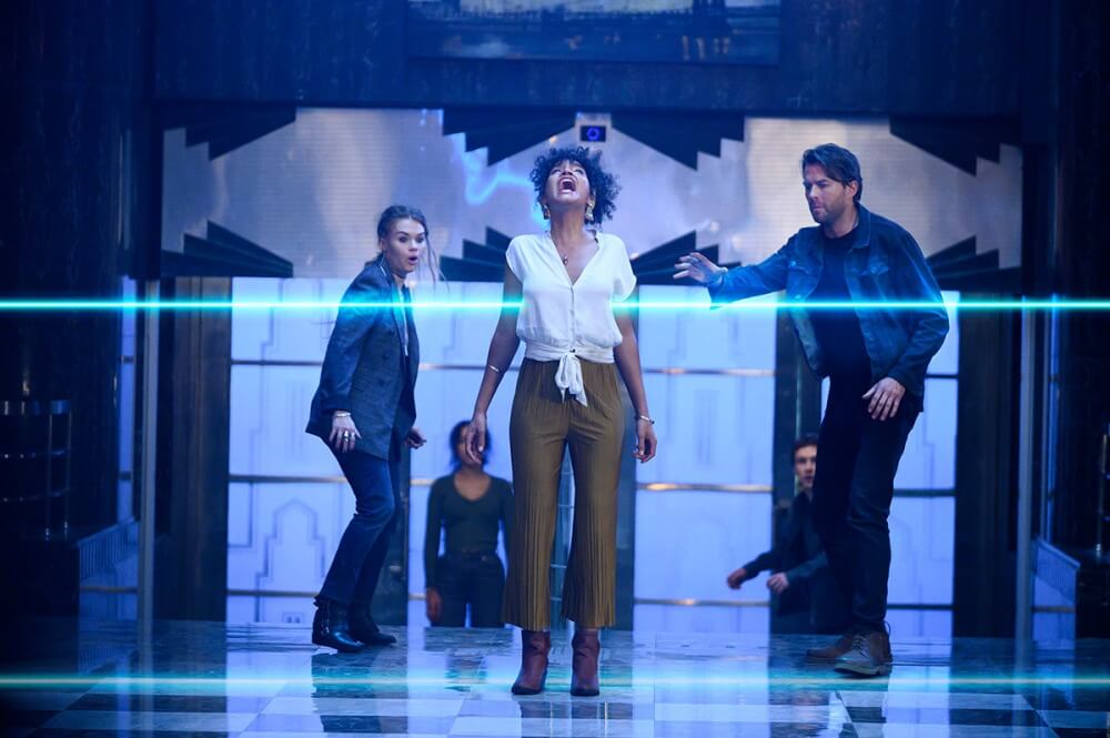 영화 이스케이프 룸 2 스틸컷 – 참가자들이 치명적인 함정 앞에서 긴장감 속에 서 있는 장면