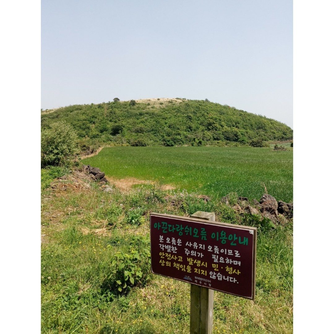 아끈다랑쉬오름 이용 안내판과 오름 전경