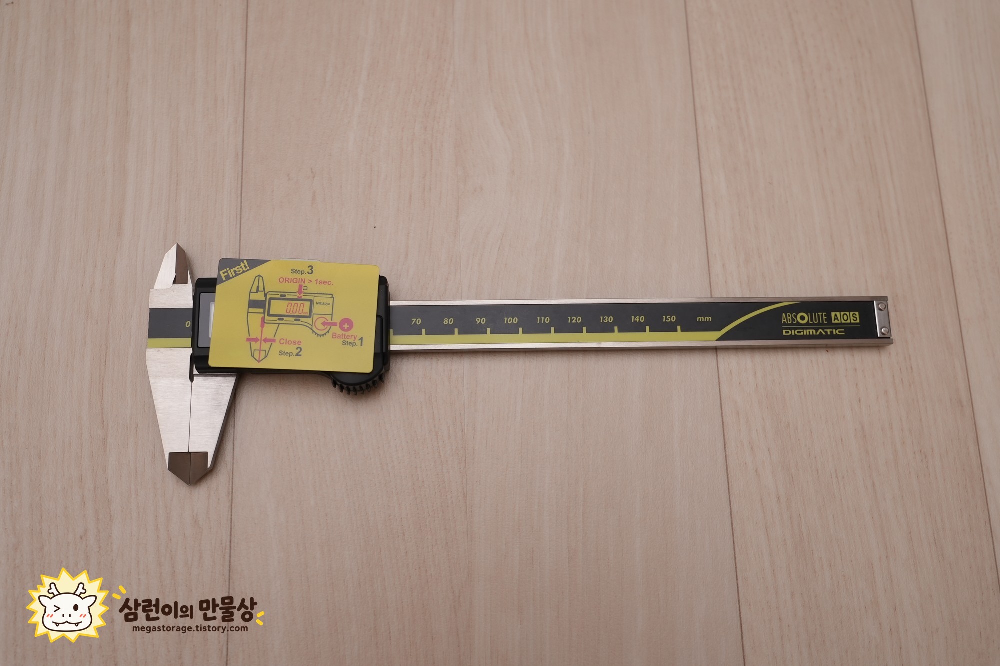 초기 설정 안내 스티커가 붙어 있는 캘리퍼스