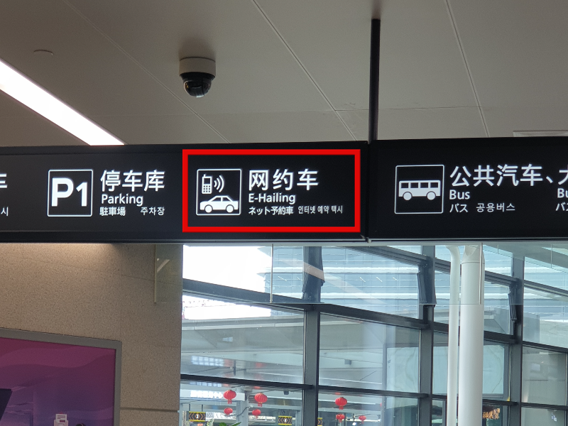 천장에 달린 안내표지판에 주차, 인터넷 예약 택시, 공용 버스 등의 안내판