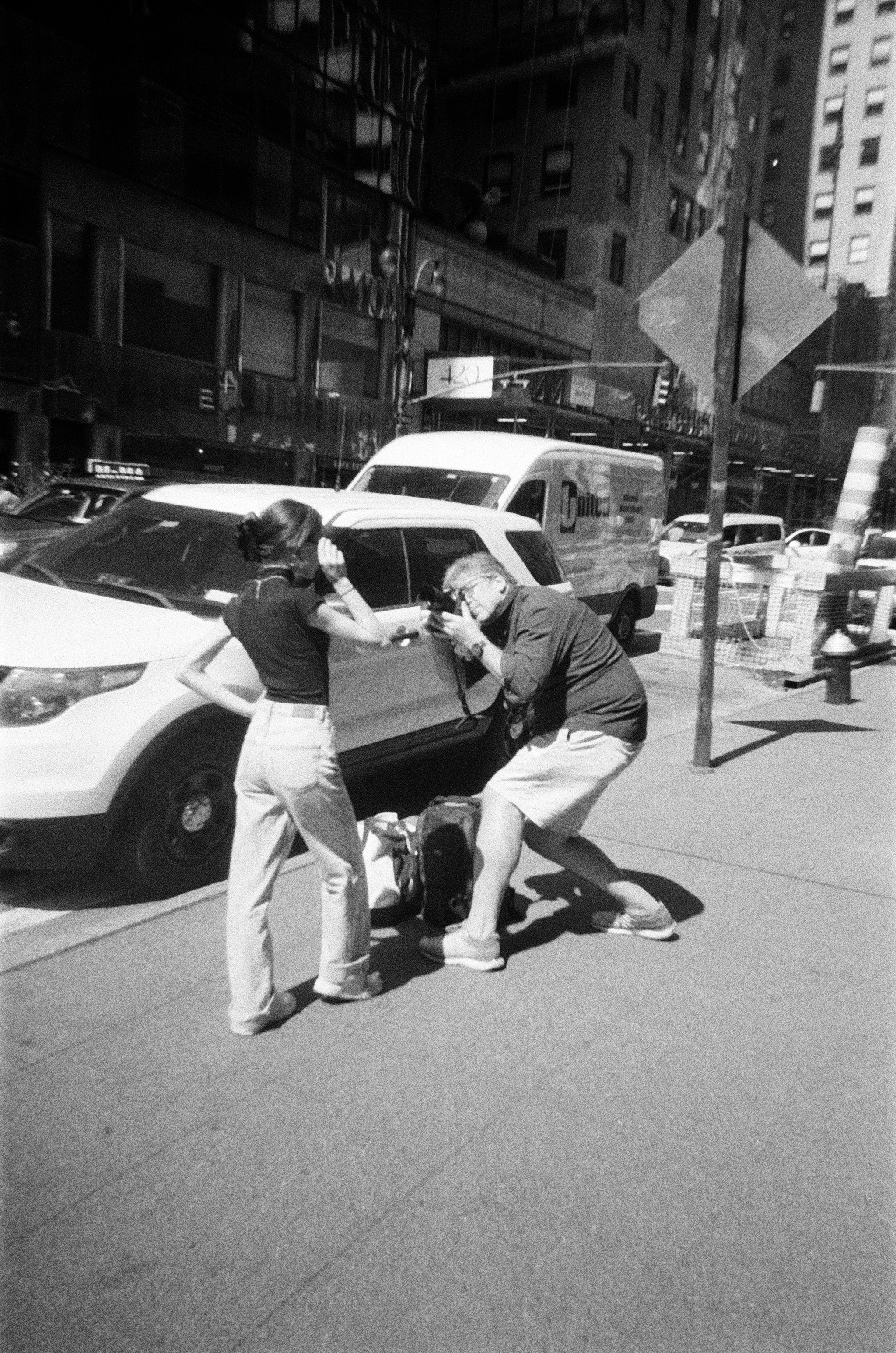 도심에서 여성 인플루언서를 남성 포토그래퍼가 카메라로 촬영하는 장면