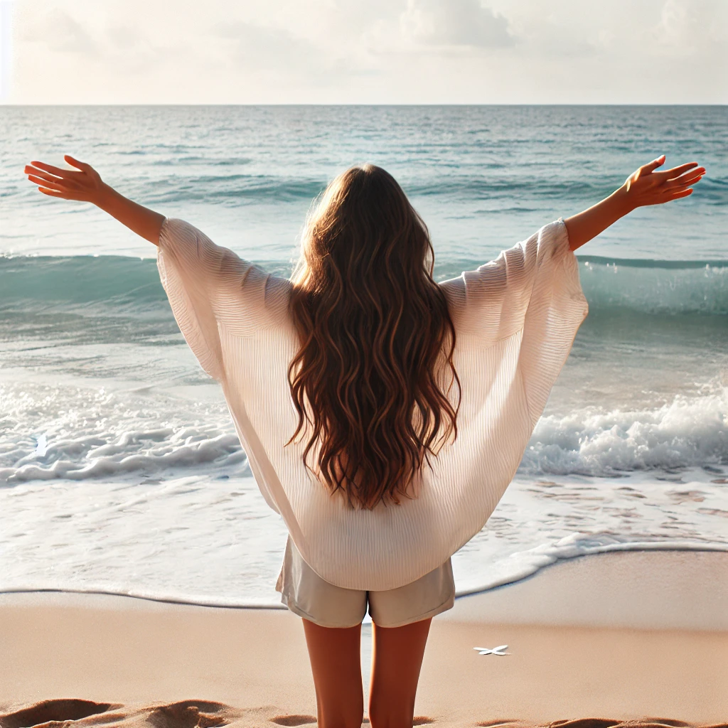 해변에서 양팔벌려 바닷바람을 즐기는 여성 사진