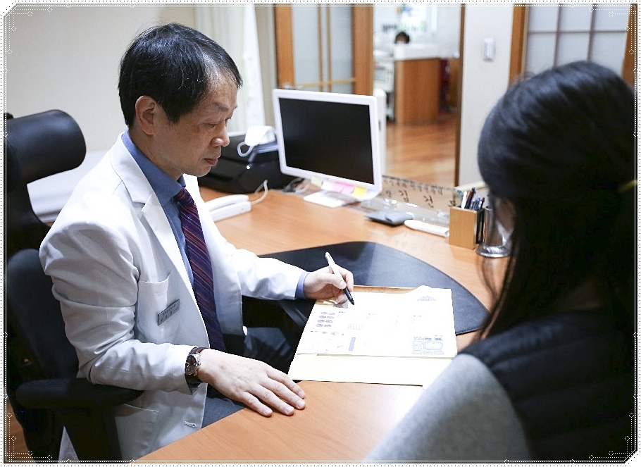 차트를 보며 진료 중인 한의사와 환자의 모습