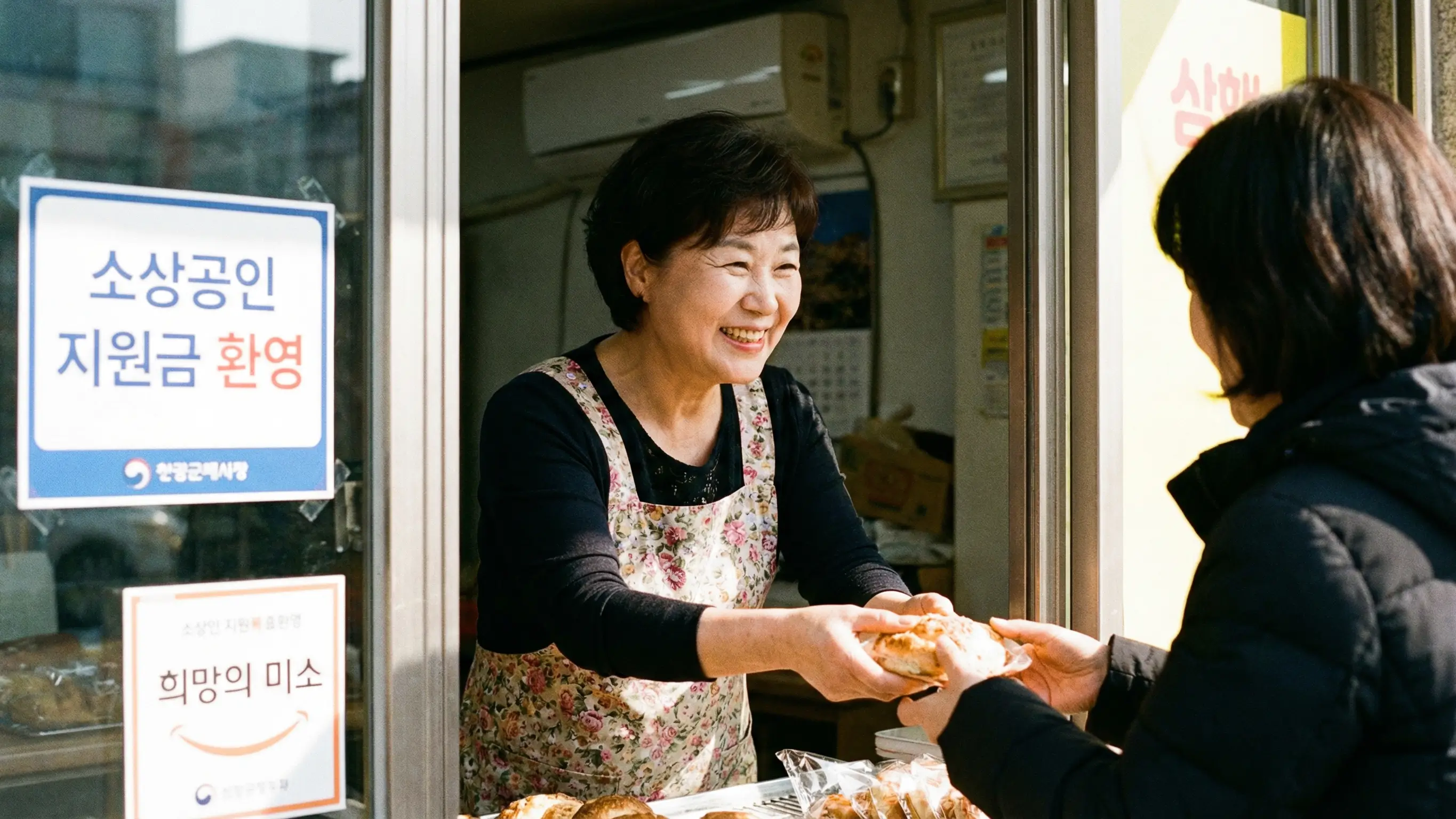 지원금을 받아 가게 운영의 걱정을 덜고 밝은 미소로 손님을 맞이하는 영세 자영업자의 희망찬 모습