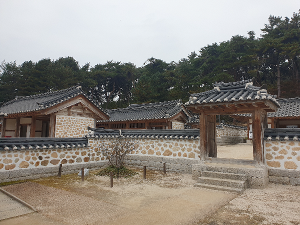 재실 마당이 보이고 그 뒤에 다른 건물로 들어가는 문이 보인다.