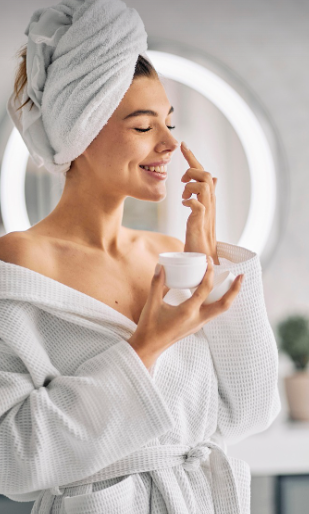 머리에 수건을 두르고 스킨케어를 하고 있는 여자