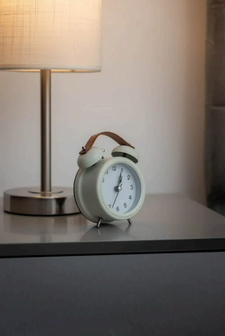 협탁 위 알람시계와 스탠드 조명, 스마트폰 대신 아날로그 알람 사용