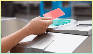 빨간색 비접촉식 카드를 들고 지하철 출입구에서 검증자 위에 있는 사람의 손 클로즈업