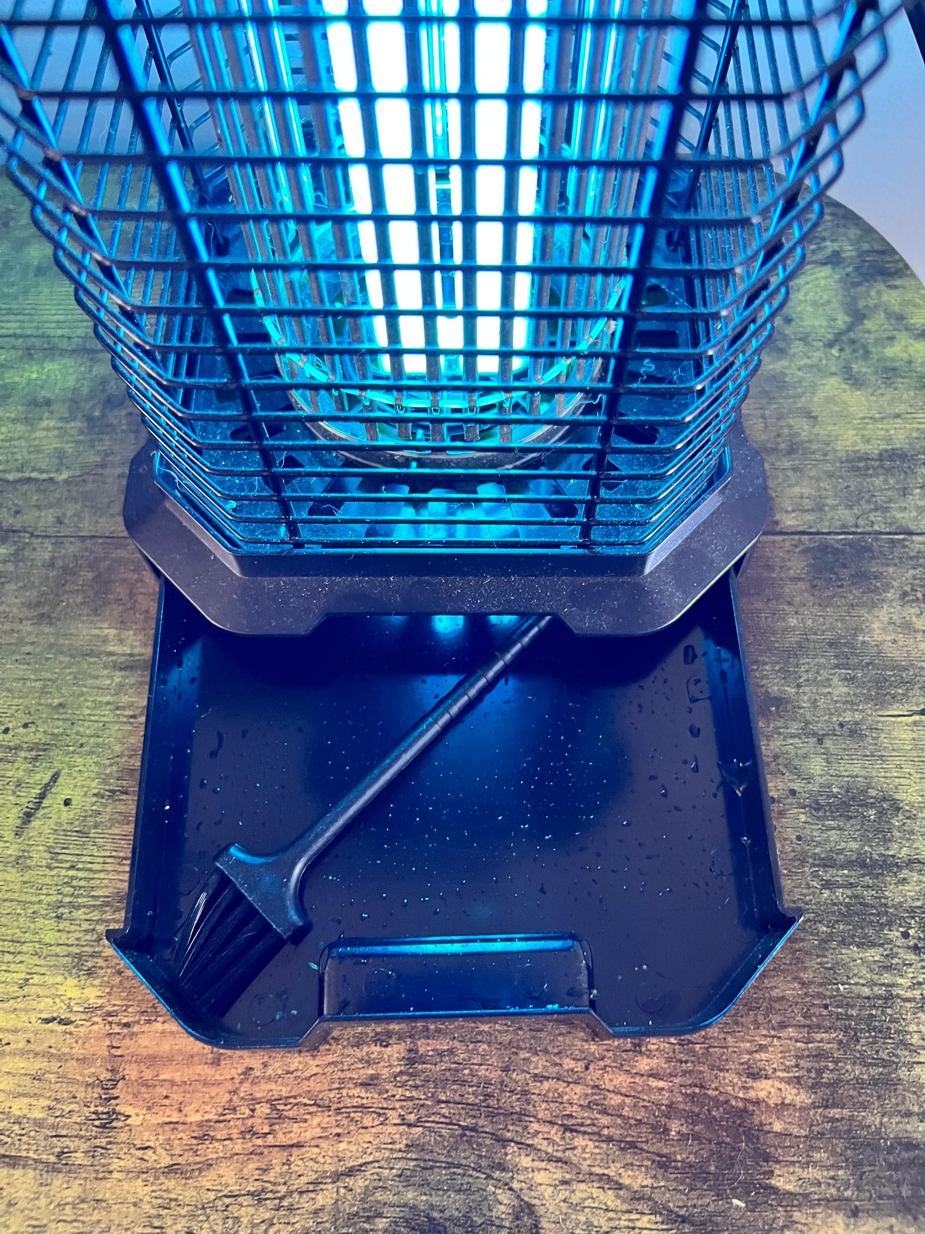 전기 해충 퇴치기의 전훤이 켜진 모습과, 밑에 수거받침과 작은 브러쉬가 있는 이미지