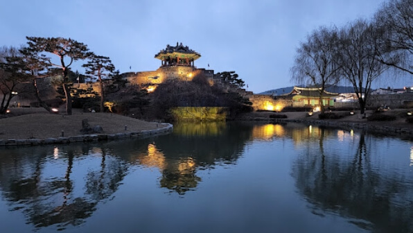 수원 화성 방화수류정의 저녁 야경과 물에 비친 누각 반영이 아름답게 어우러진 전경