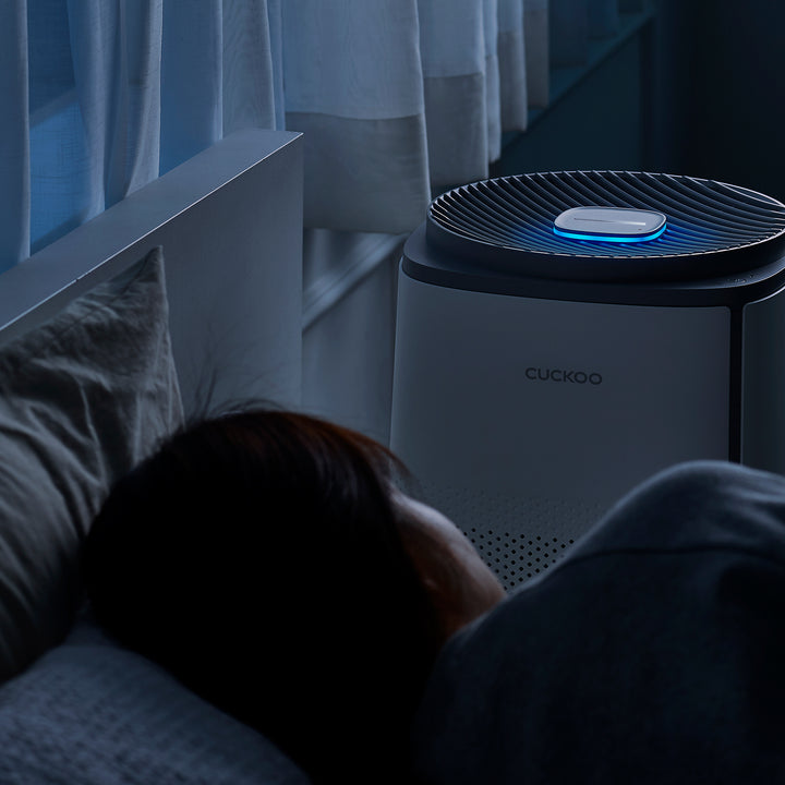 Cuckoo air purifier in a cozy living room with natural light and plants.