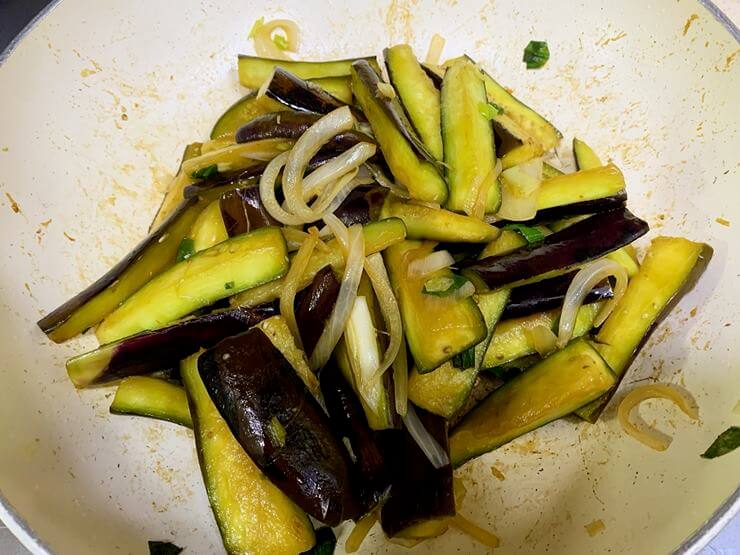 팬에 간장과 굴소스 양념에 묻은 가지와 양파가 섞여있다.