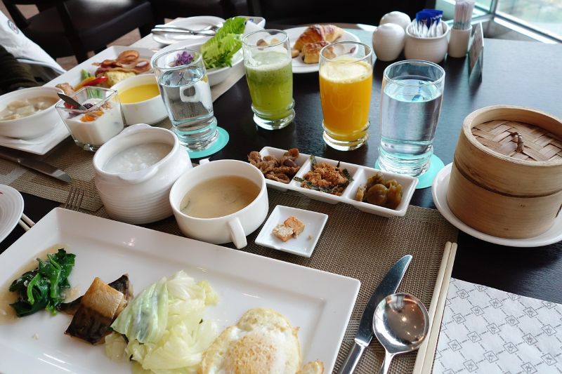 “대만 호텔 식당에서 제공되는 정갈한 아침식사 테이블, 죽과 계란요리, 죽염 반찬, 다양한 주스와 딤섬까지 차려진 풍성한 한 상”