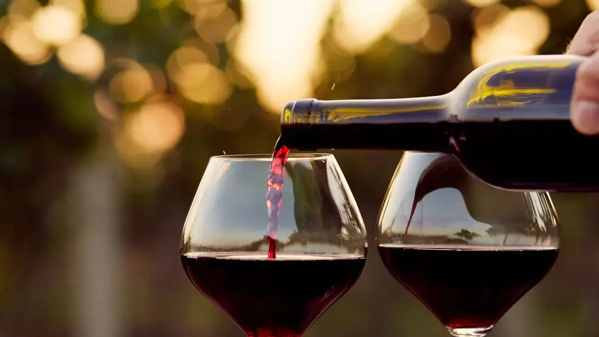 레드와인을 와인잔 두개에 따르고 있는 모습