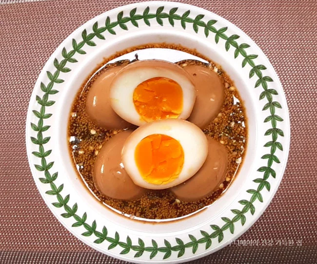 숙성된-다이어트-계란장을-그릇에-담고-위에-올려진-계란-1개를-반으로-잘라-노른자가 보이게-놓은-모습