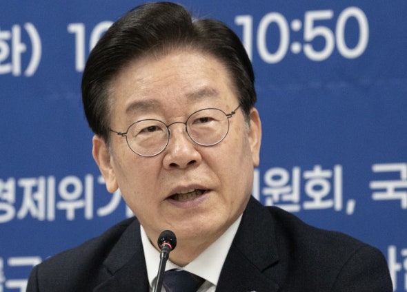 이재명 대통령이 현수막 앞에서 마이크를 대고 발표하고 있다.